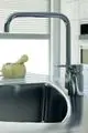 Küchenarmatur mit hohem Auslauf in Chromoberfläche, montiert am Waschbecken. Ideal Standard Produkt in modernem Küchenumfeld, mit minimalistischer Formgestaltung.